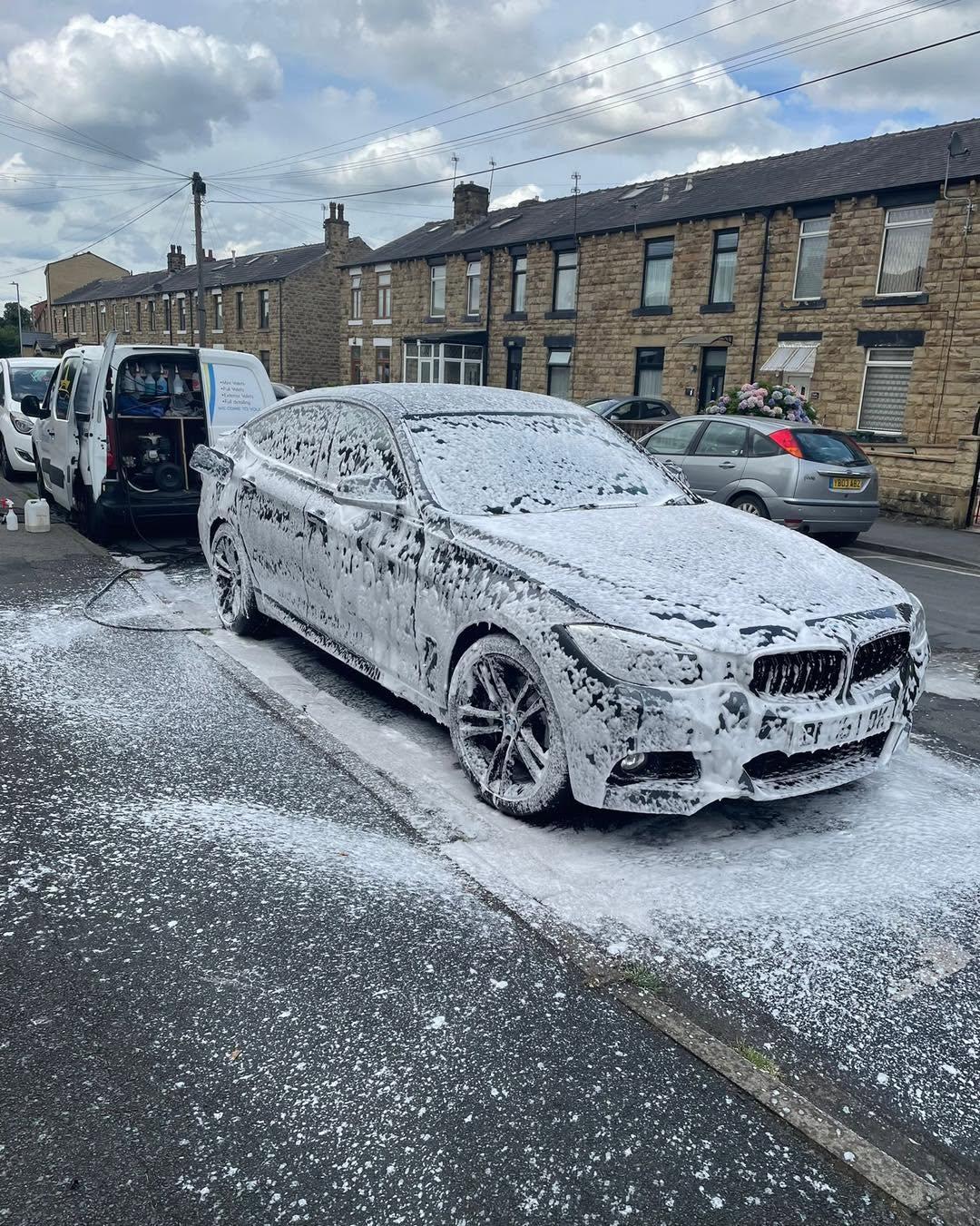 BMW covered in snow foam during a wash